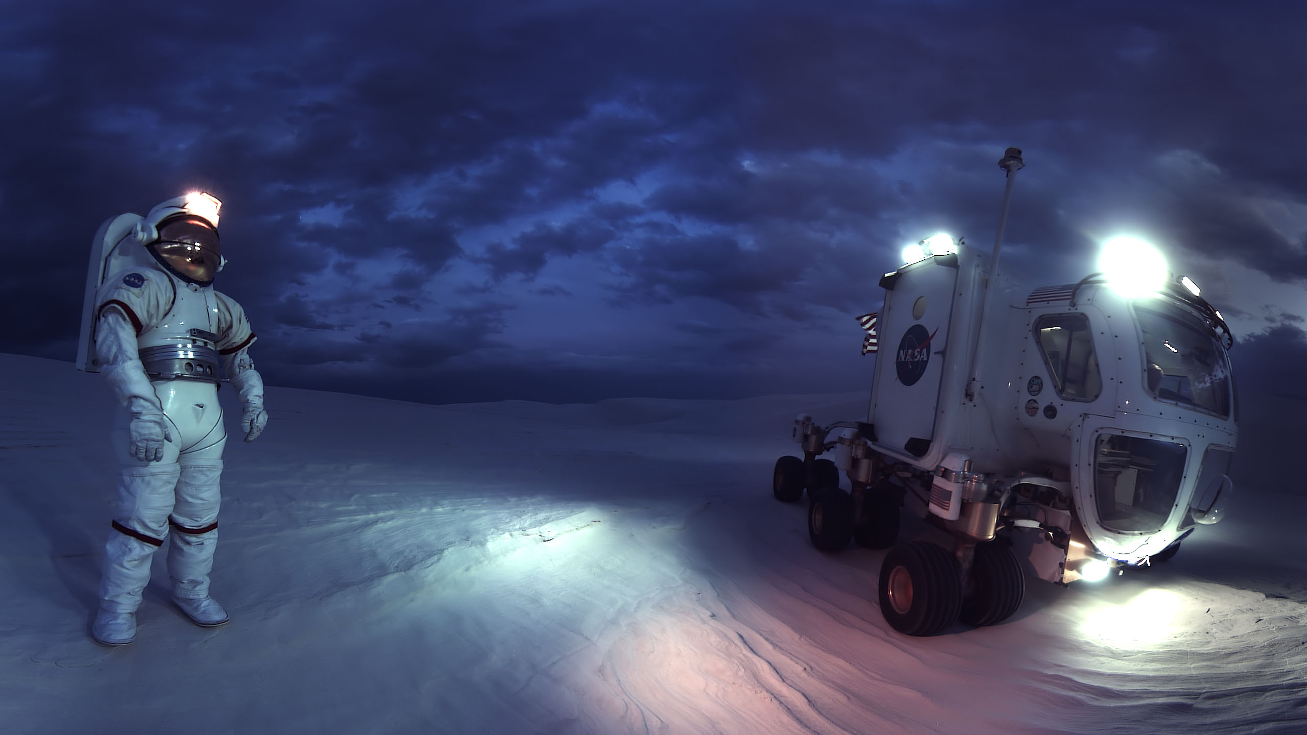 Astronaut at night on a desert plane with a rover near them.